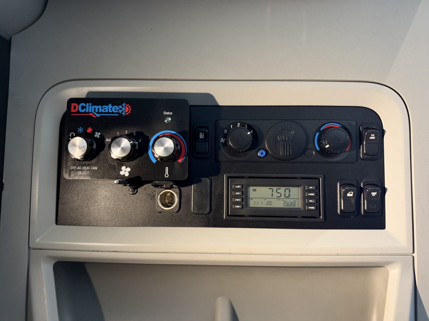 Kenworth T680 dash panel showing DC Climate climate control unit and digital radio display.