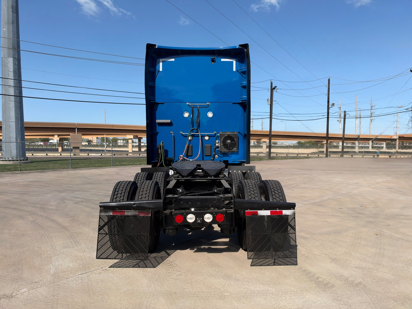 Kenworth T680 tractor rear view showing back of cab and chassis, with twin rear fenders and electrical/air lines visible