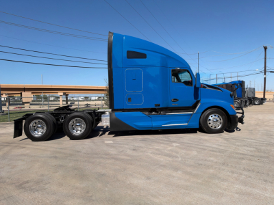 Kenworth T680 sleeper cab with blue exterior side view showing tractor chassis and rear dual axles.