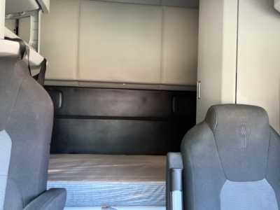 Kenworth T680 cab interior showing sleeper berth with mattress and side wall panels.