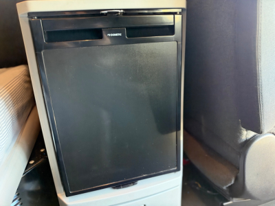 Kenworth T680 interior center console with a black refrigerator appliance visible, front view showing plain panel and control slot.