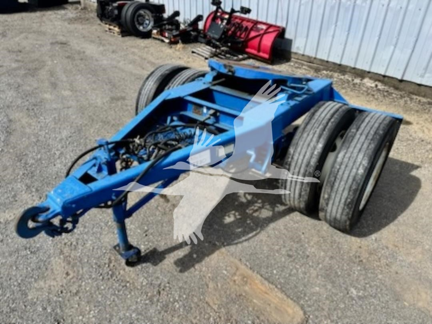 Blue Stoughton single-axle dolly chassis on lot with dual rear axles and hitch, showing VIN RB1821 and stock number 7880 in listing.