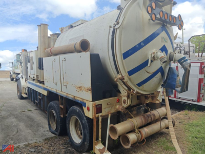 Vacuum truck rear and side view showing cylindrical tank, rear hoses, and warning stripes.