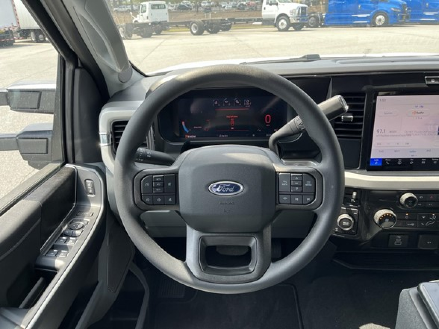 Ford F-350 interior dashboard view showing steering wheel with Ford logo, digital instrument cluster, and center touchscreen infotainment system.
