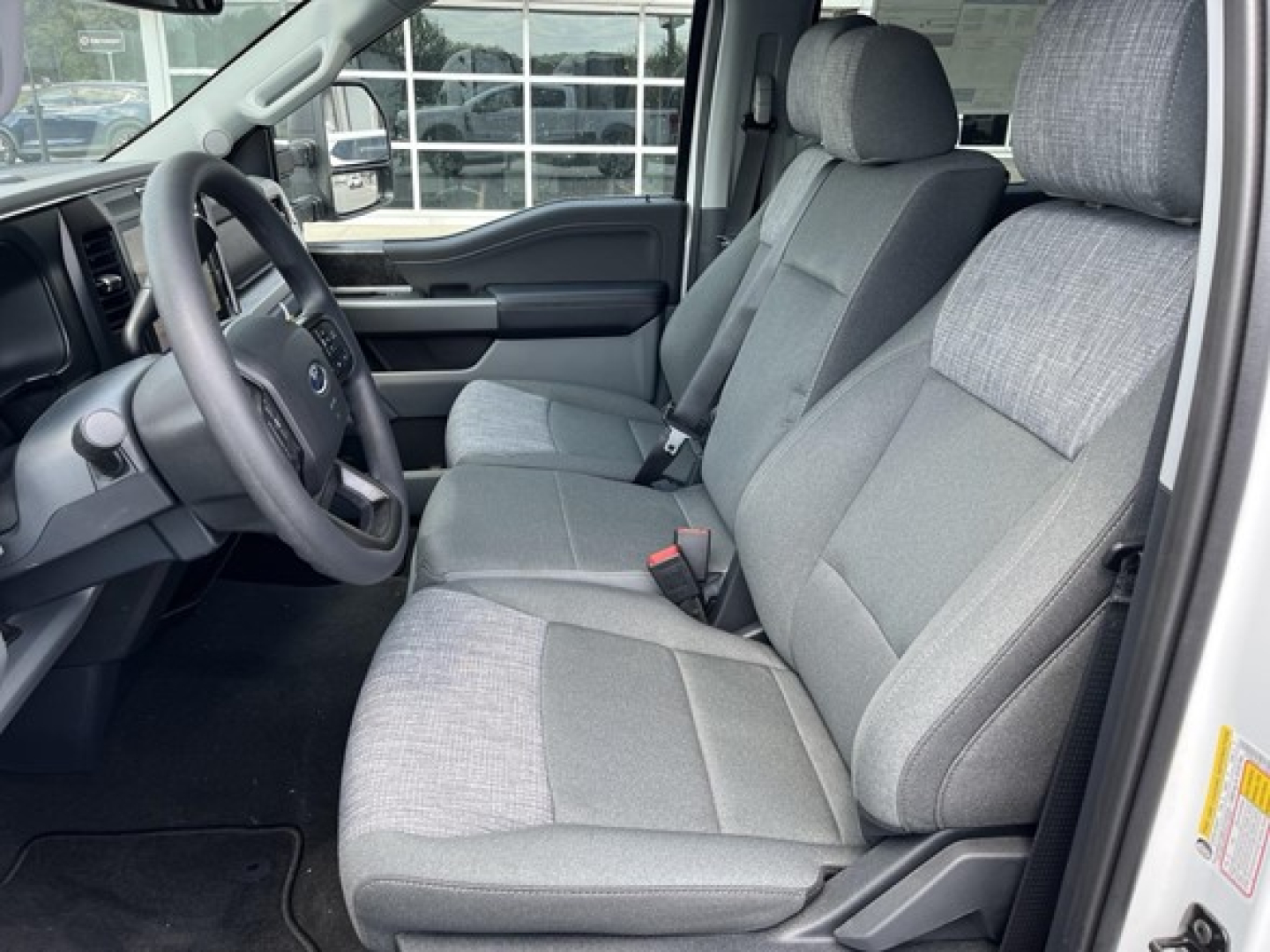 Ford F-350 interior front seats and steering wheel, gray cloth upholstery, driver and passenger seats, dashboard, and door panel visible.