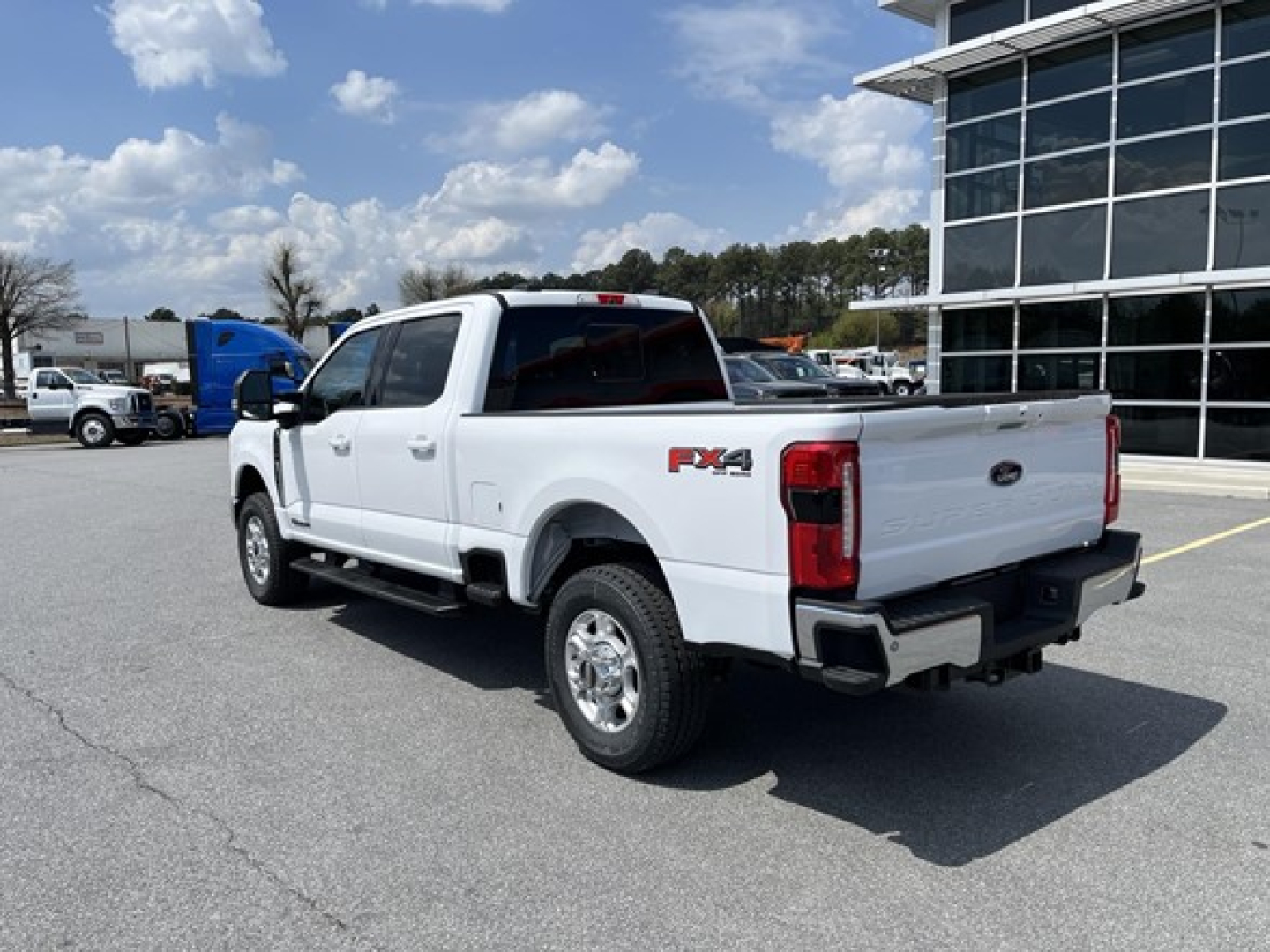 Ford F-350 pickup truck in white, 2WD FX4 badge on rear fender, side view showing truck bed and chrome wheels.