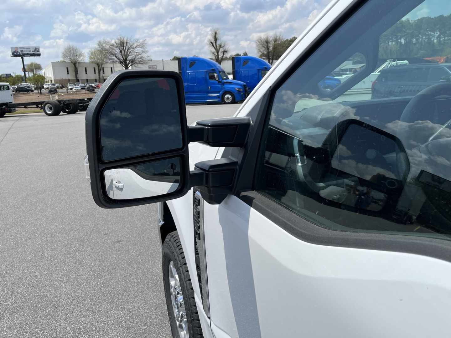 Ford F-350 pickup truck side mirror and front door view showing exterior, white body, and side mirror assembly.