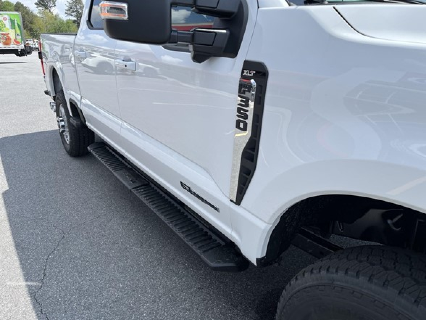 Ford F-350 pickups side view showing running board and XLT badge on front fender.