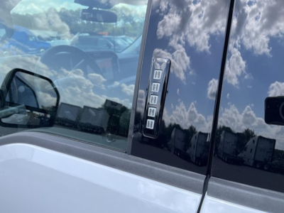 Ford F-350 door label area showing Z-shaped vertical window sticker with multiple icons and glossy black trim.