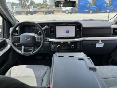 Ford F-350 interior view showing steering wheel with Ford logo, central touchscreen infotainment, climate controls, and dashboard from driver’s seat.