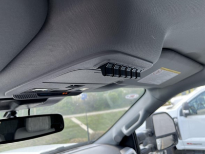 Ford F-350 interior roof console with controls and sun visor area, view through driver's door side mirror.