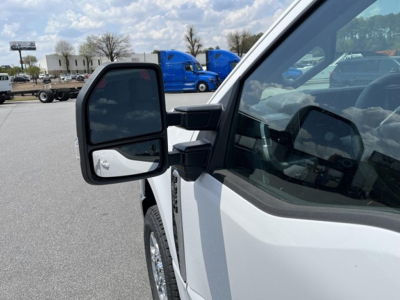 Ford F-350 pickup truck mirror and front cab area showing side mirror and part of door, white paint.