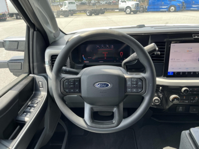 Ford F-350 cockpit view showing steering wheel with controls and digital instrument cluster, center touchscreen display, and dashboard details.