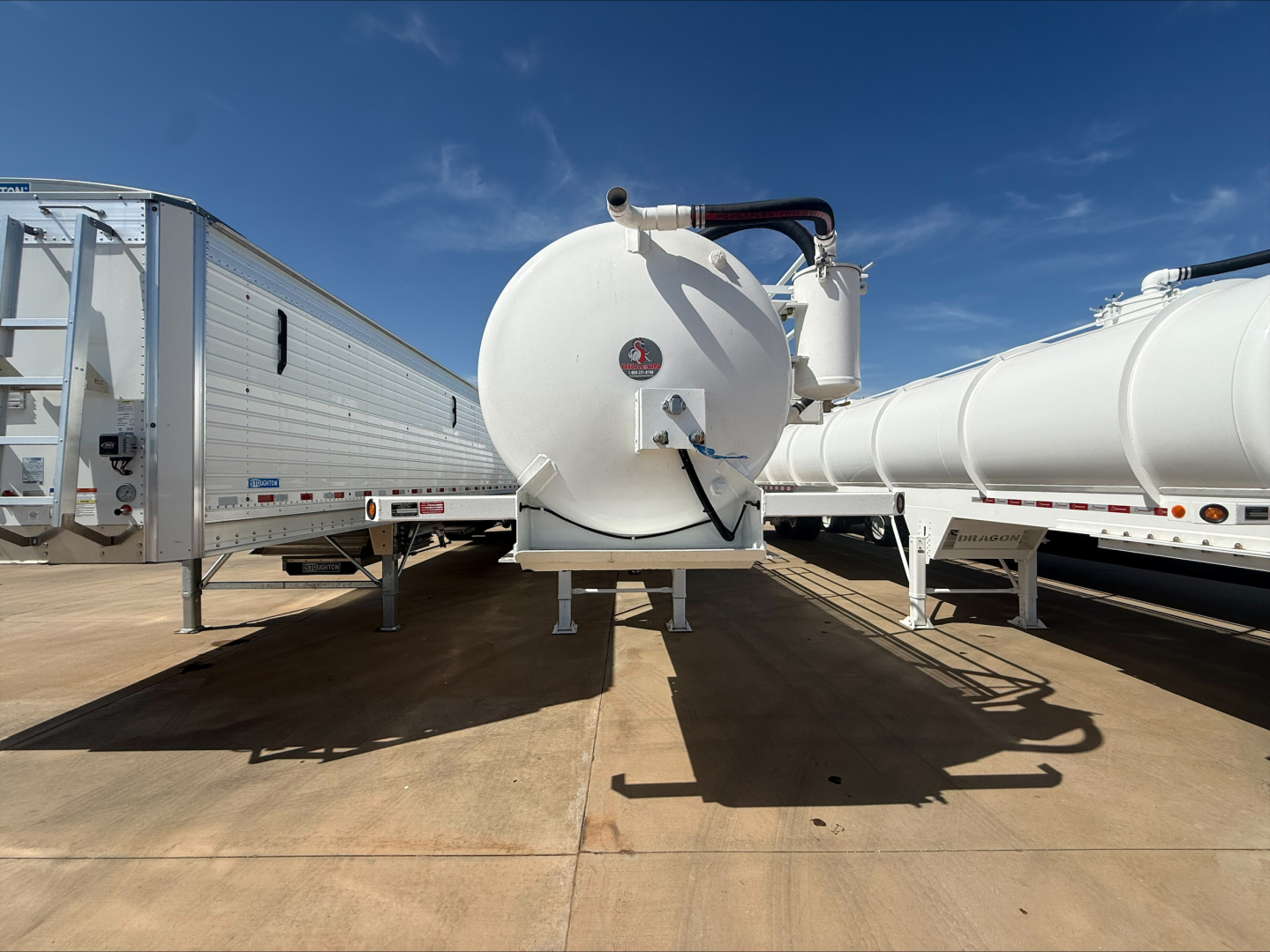 Vacuum trailer back view showing circular tank with manometer and piping between two trailers.