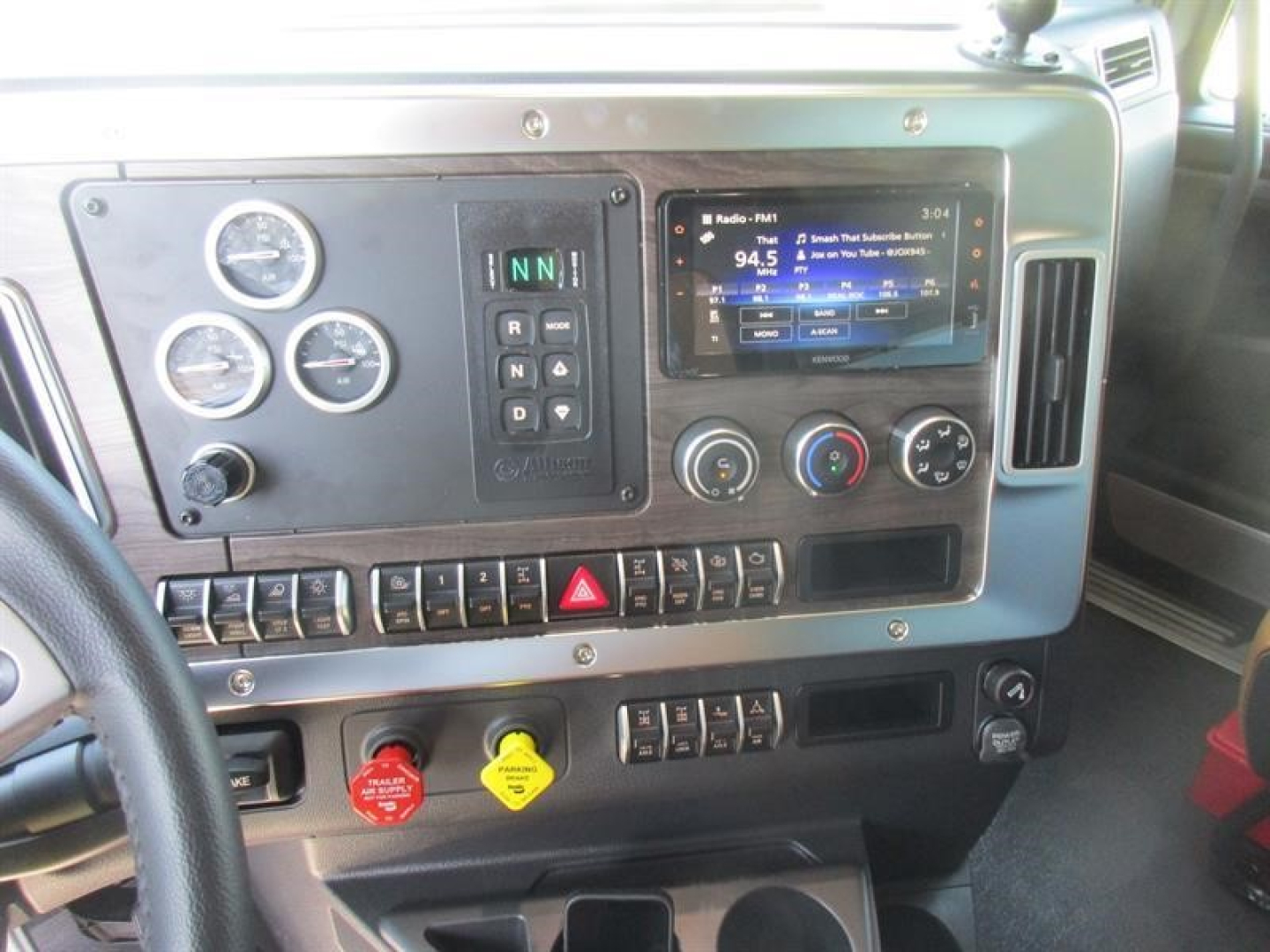Cab interior of a new Western Star 49X dump truck showing instrument cluster, climate controls, radio display, and rows of switches.