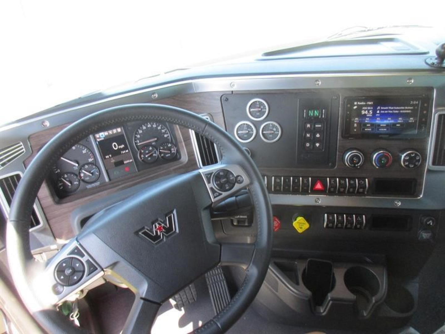 Western Star truck cabin dashboard and steering wheel showing instrument cluster and infotainment screen.
