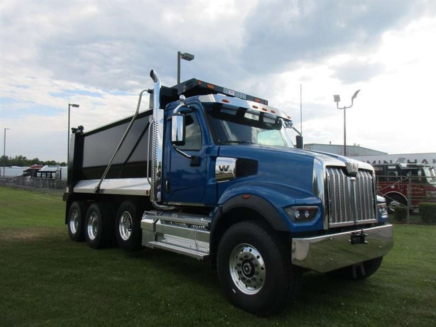 Western Star 49X dump truck in blue, side view showing front grille, chrome bumper, dual rear axles, and dump bed.