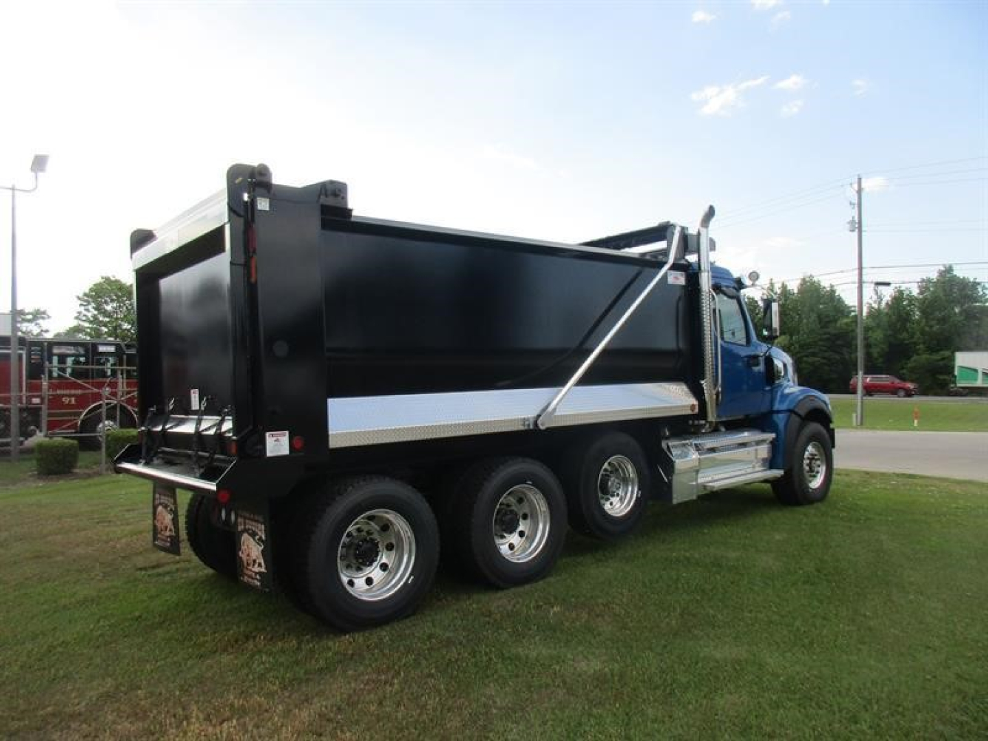 Western Star 49X dump truck side rear view showing black dump bed and chrome wheels.