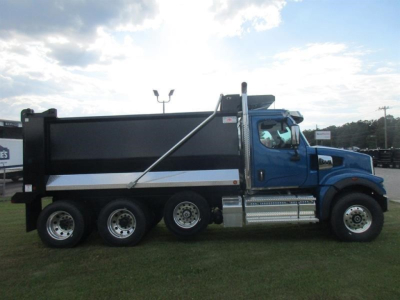 Dump truck side view showing blue Western Star 49X with black dump bed and chrome steps, six-wheel configuration, and VIN/stock visible on listing.