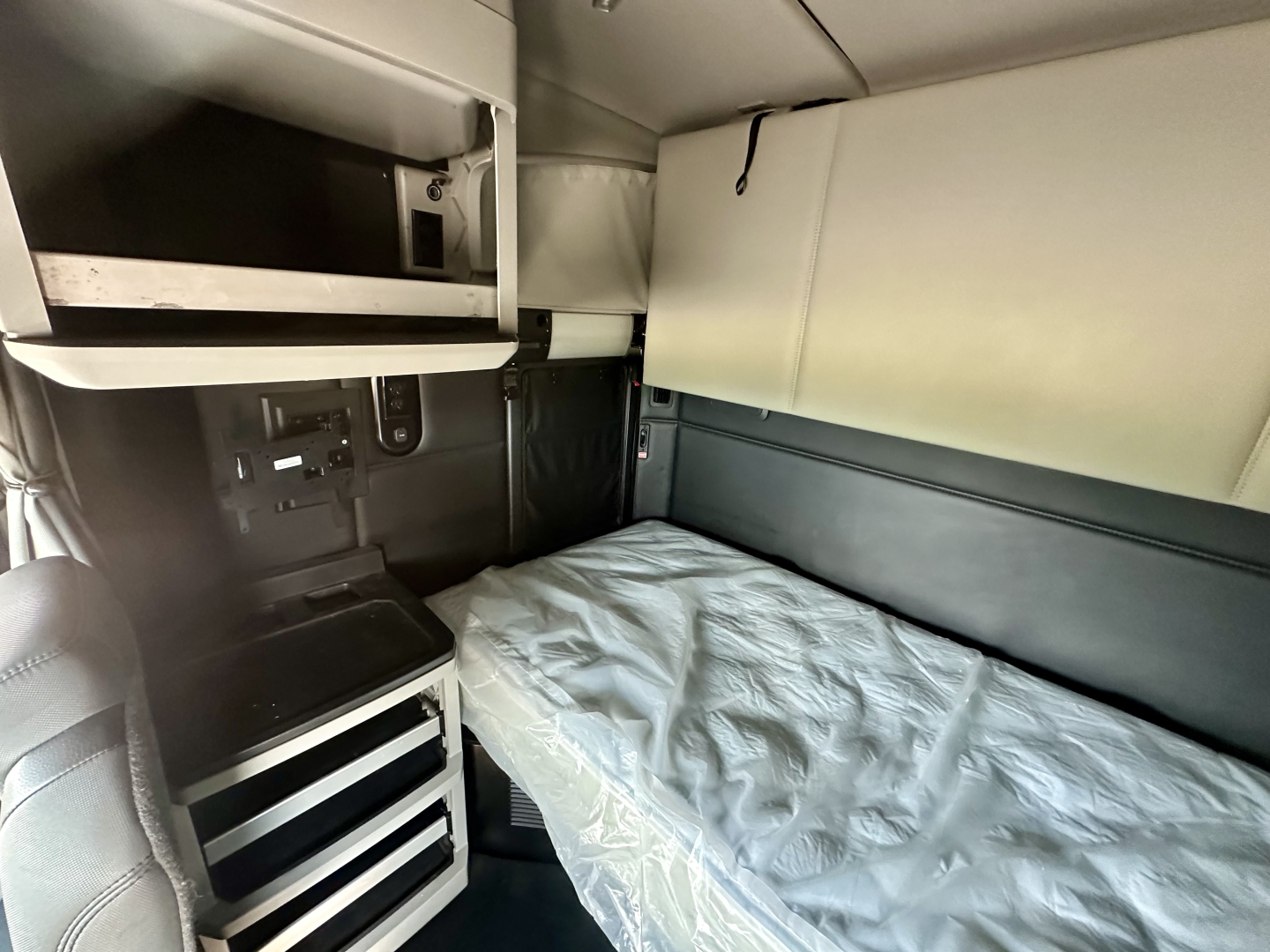 Kenworth T680 sleeper cab interior showing bunk bed and storage cabinets