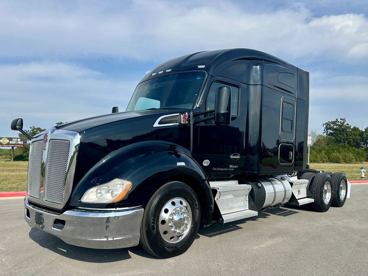 Kenworth T680 conventionals sleeper semi-truck in black with chrome grille and dual rear axles seen from side.