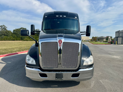 Kenworth T680 truck front view showing large chrome grille and bumper with headlights and mirrors.