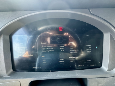 Truck instrument cluster display showing vehicle information: Classis, Make, Model, Engine Hours, Transmission, ABS, VIN not fully readable, various engine and dashboard data.