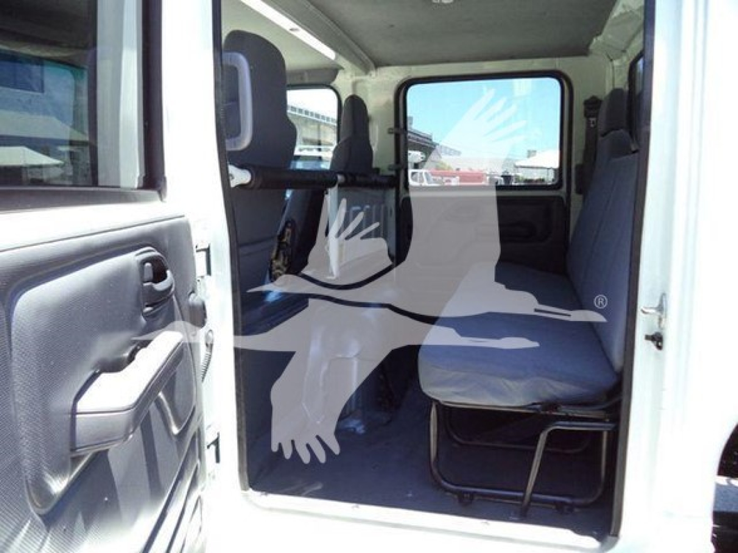 Isuzu NPR HD cab interior and seating visible through open door showing steering area and passenger seat.