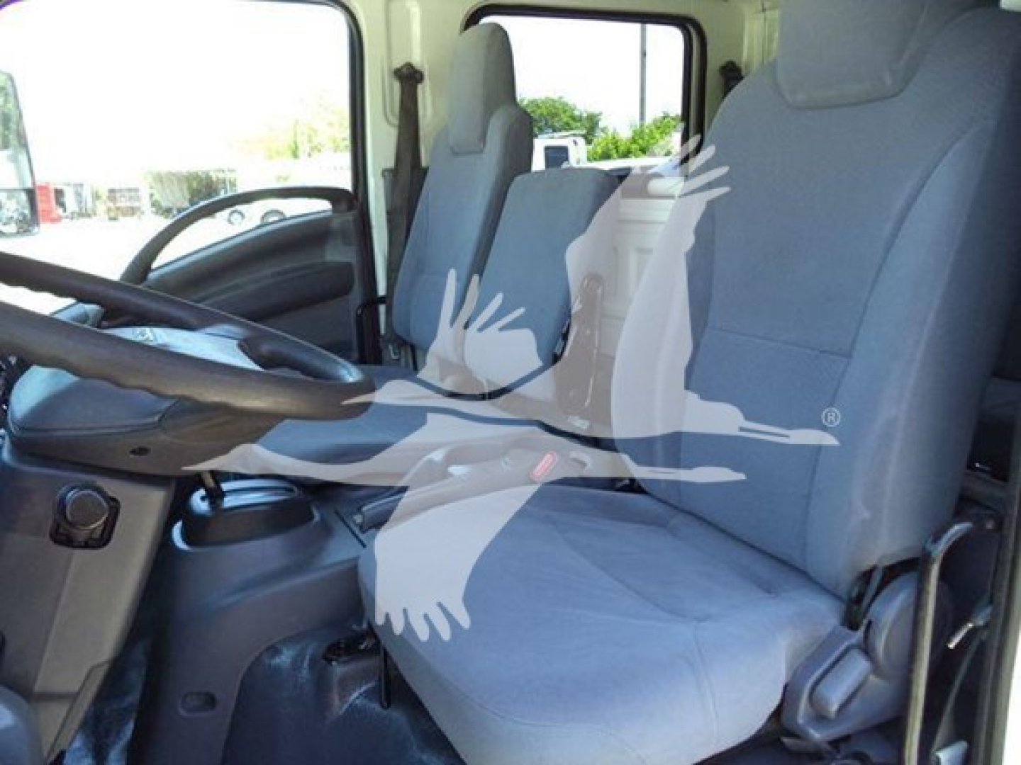Isuzu NPR HD truck cab interior showing front seats and steering wheel.