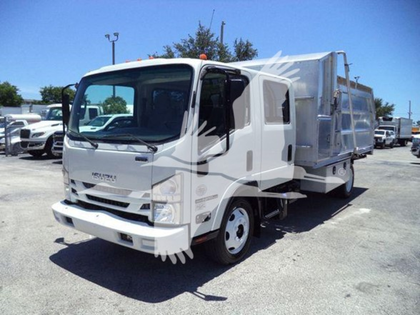 Isuzu NPR-HD dump truck in a dealership lot, white cab with a large metal dump bed.