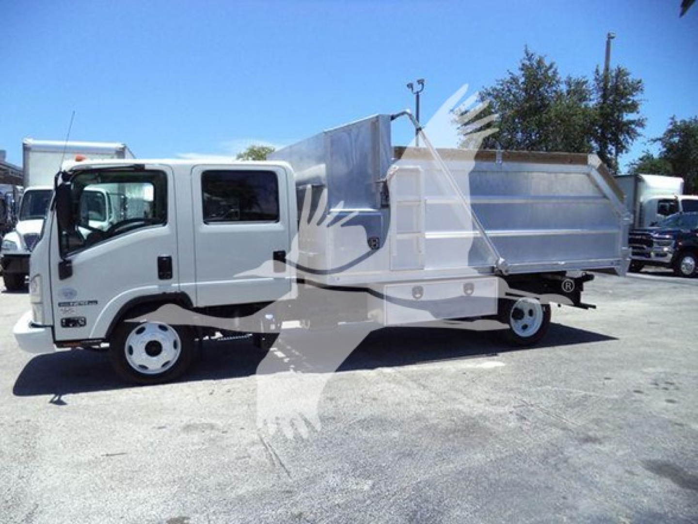 Isuzu NPR HD dump truck in view showing side profile and dump bed with hydraulic mechanism.