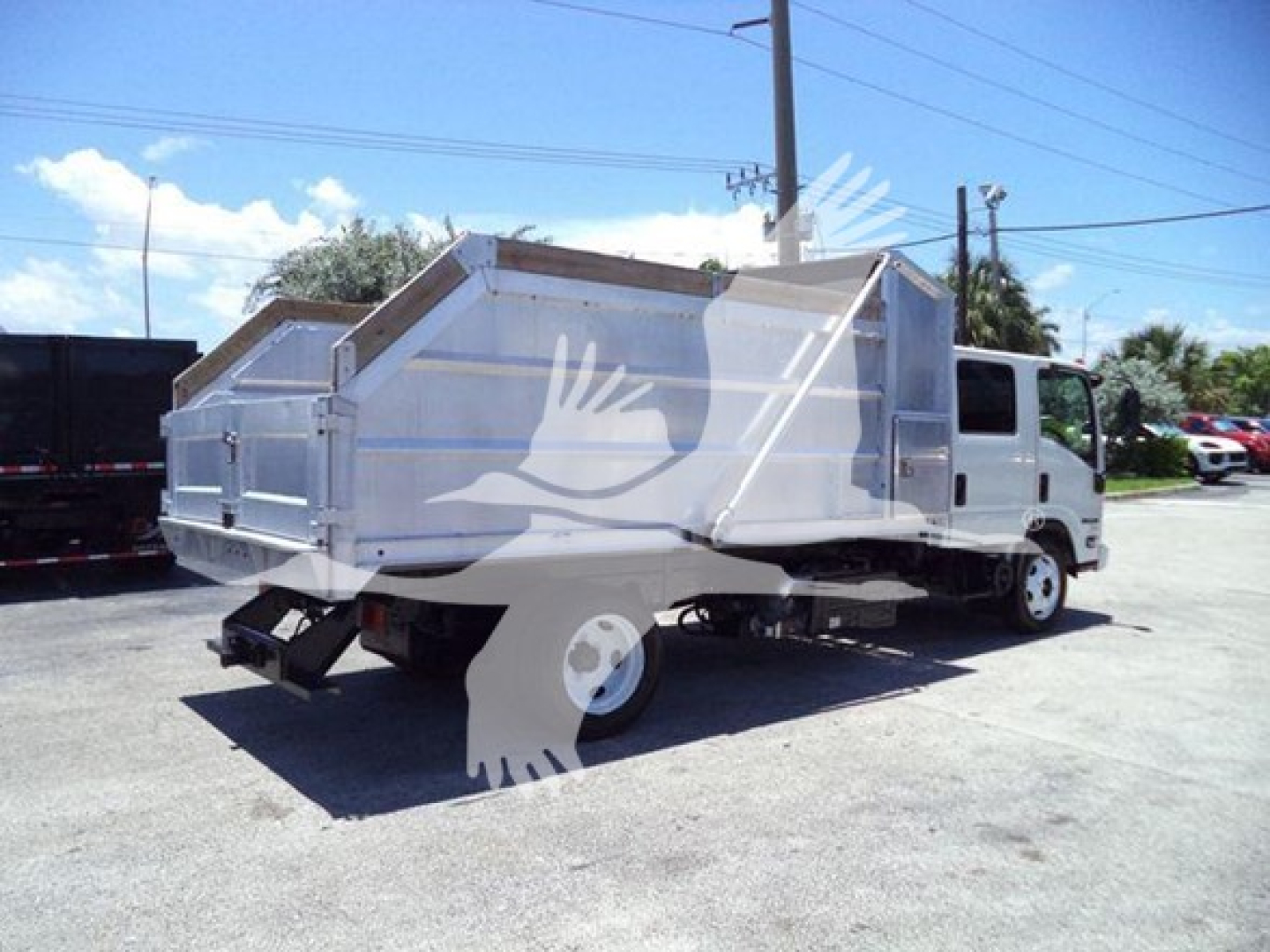 Isuzu NPR-HD dump truck shown from rear three-quarter view with large metal dump bed and white cab.
