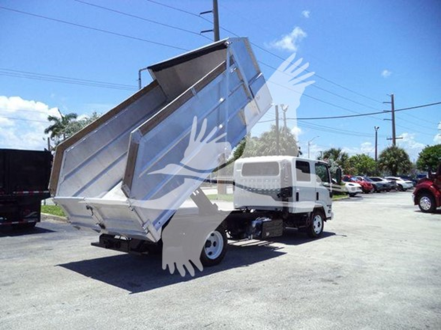 Isuzu NPR-HD dump truck with its steel dump bed raised, front cab visible in background.