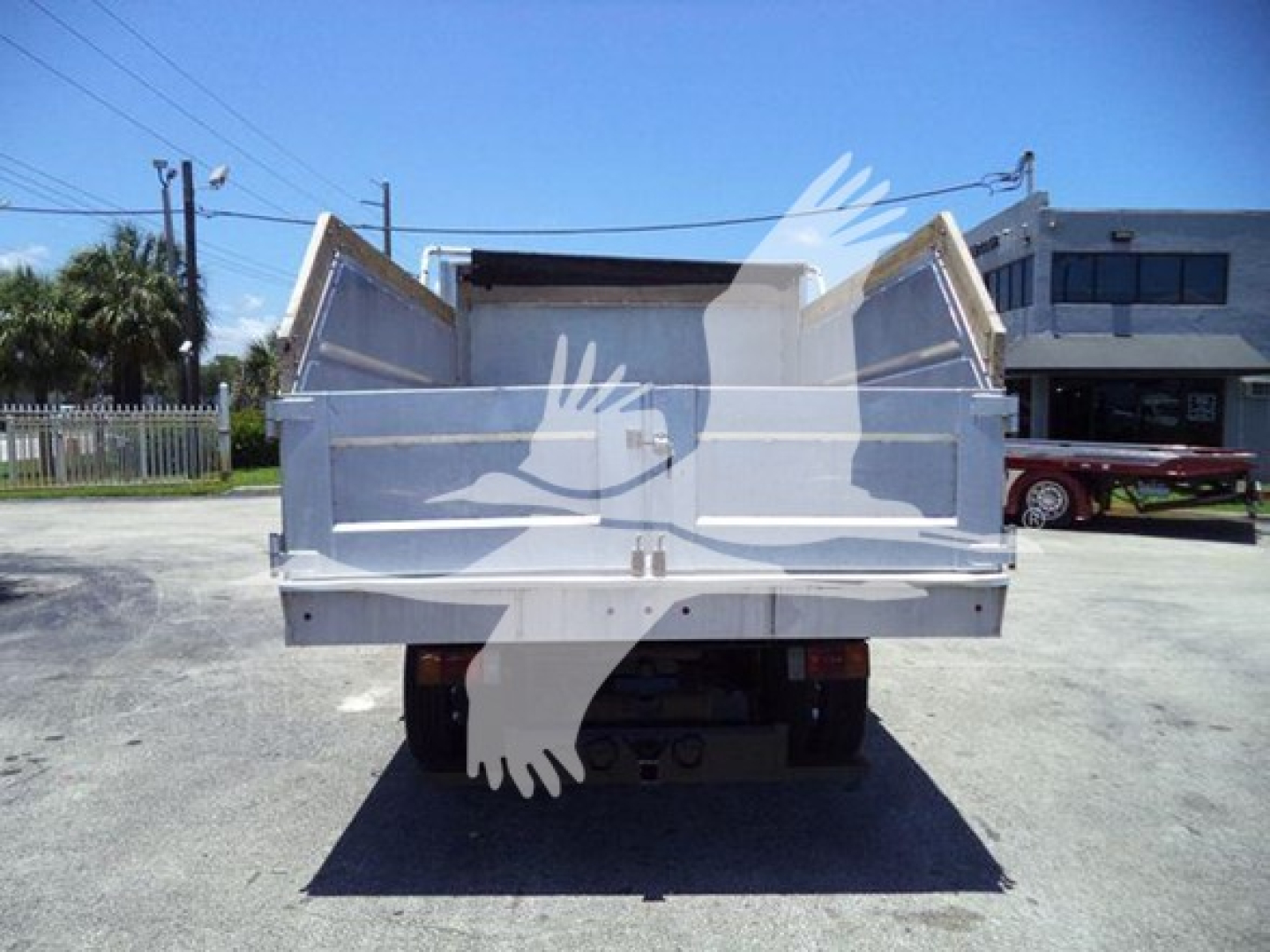 Isuzu NPR-HD dump truck rear view showing cargo bed with raised sidewalls.