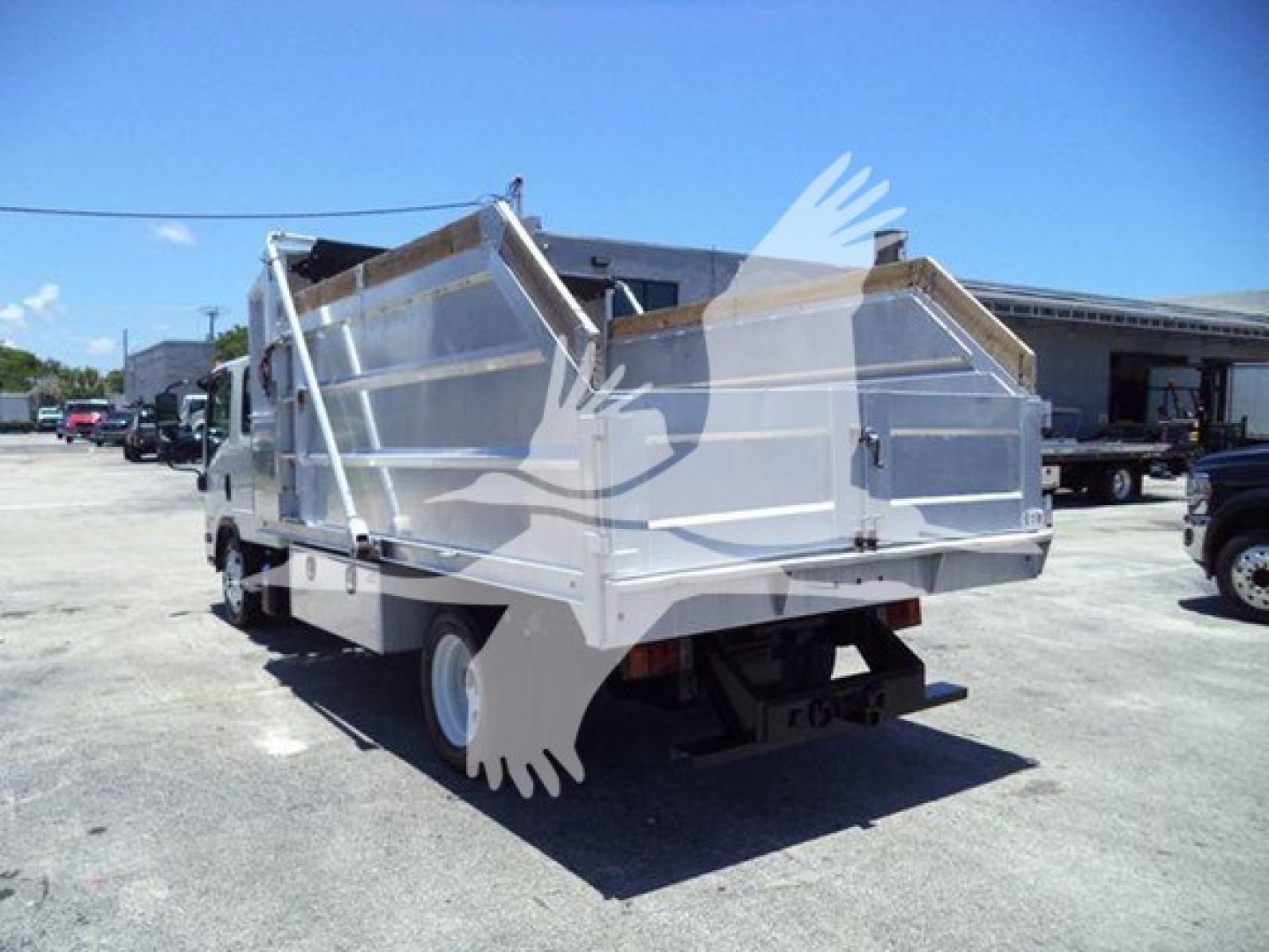 Isuzu NPR HD dump truck rear view showing aluminum dumping bed and hydraulic system