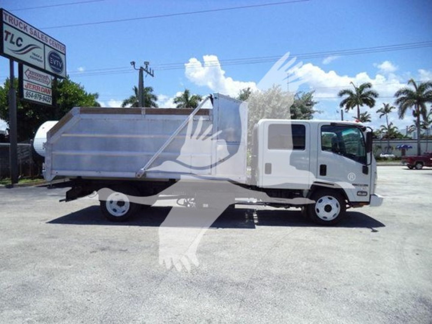 Isuzu NPR HD dump truck in side profile showing cargo bed and cab with white paint.