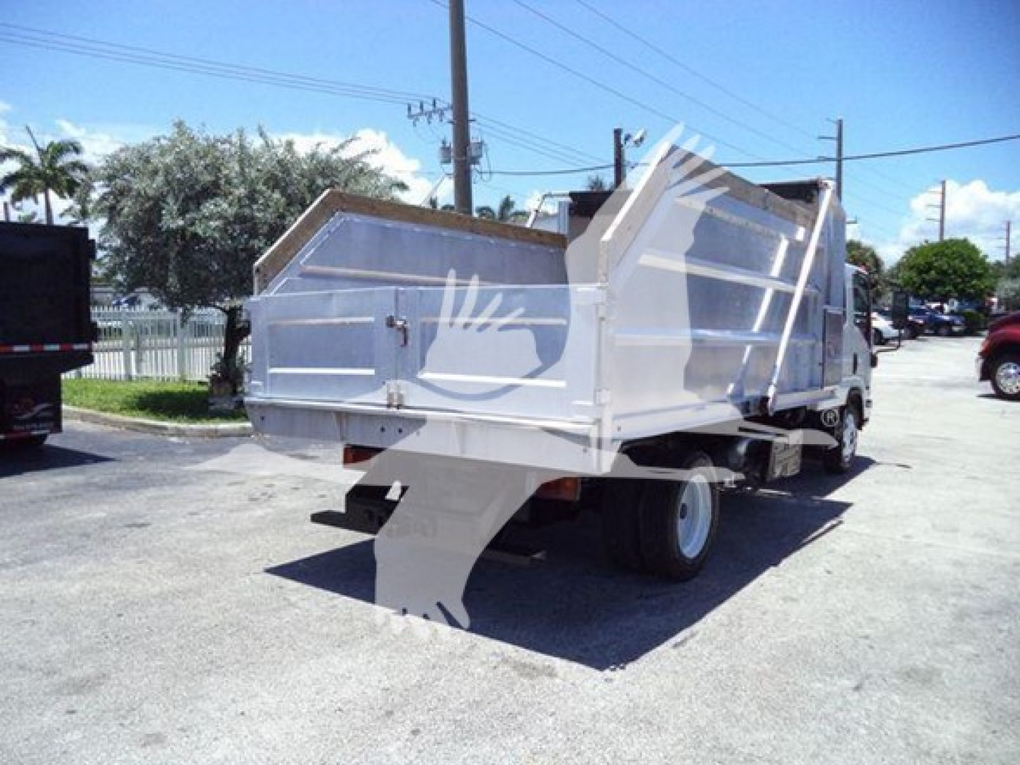 Isuzu NPR HD dump truck rear/side view showing dump bed and tailgate. Visible text includes VIN/JALC4J166N7K01859 on listing; Stock number T01859; category dump; used vehicle; 2022 Isuzu NPR HD dump truck.