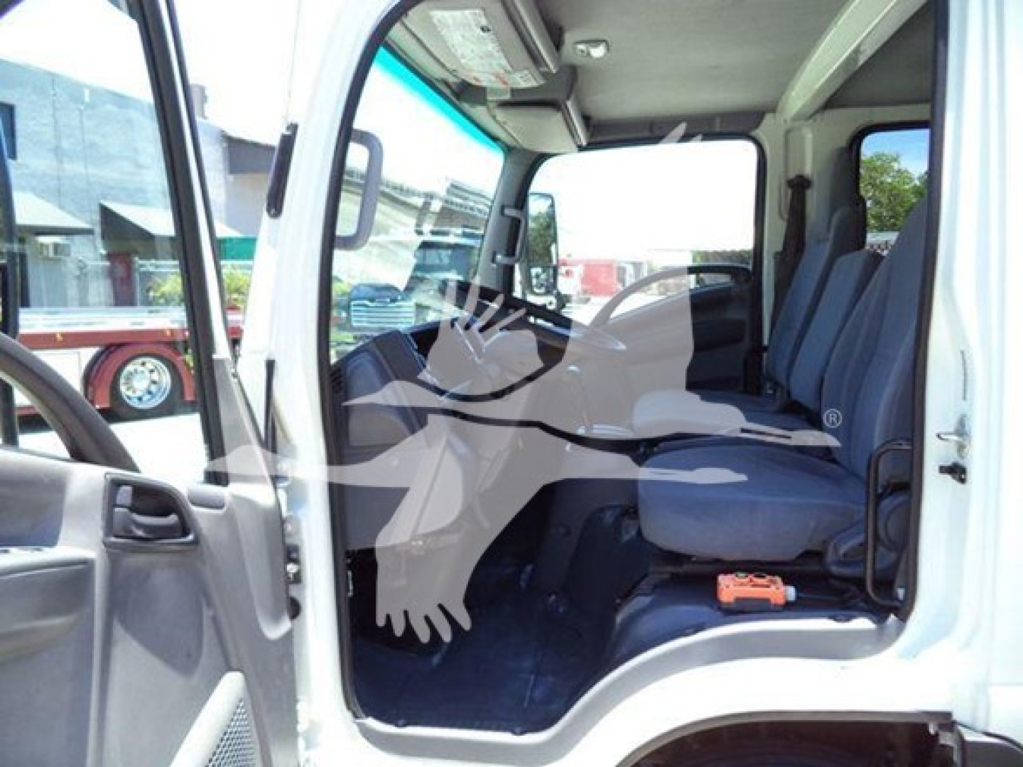Isuzu NPR HD cab interior view showing front driver seat and passenger seat with grey upholstery.