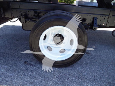 Isuzu NPR-HD truck wheel and underside view showing white steel wheel and tire with chassis components above.