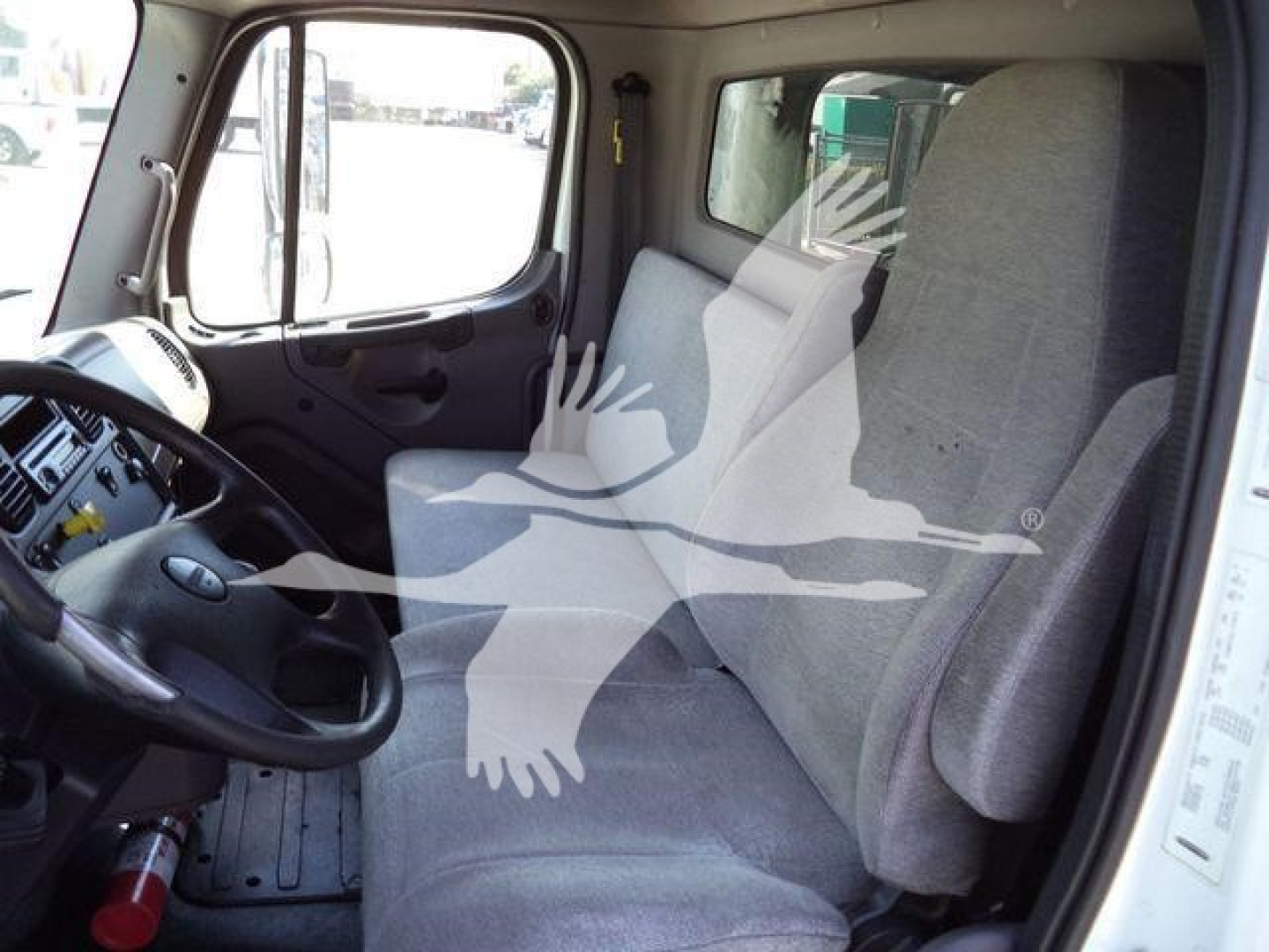 Cab interior of a 2016 Freightliner M2 106 truck showing steering wheel and driver seat in view.