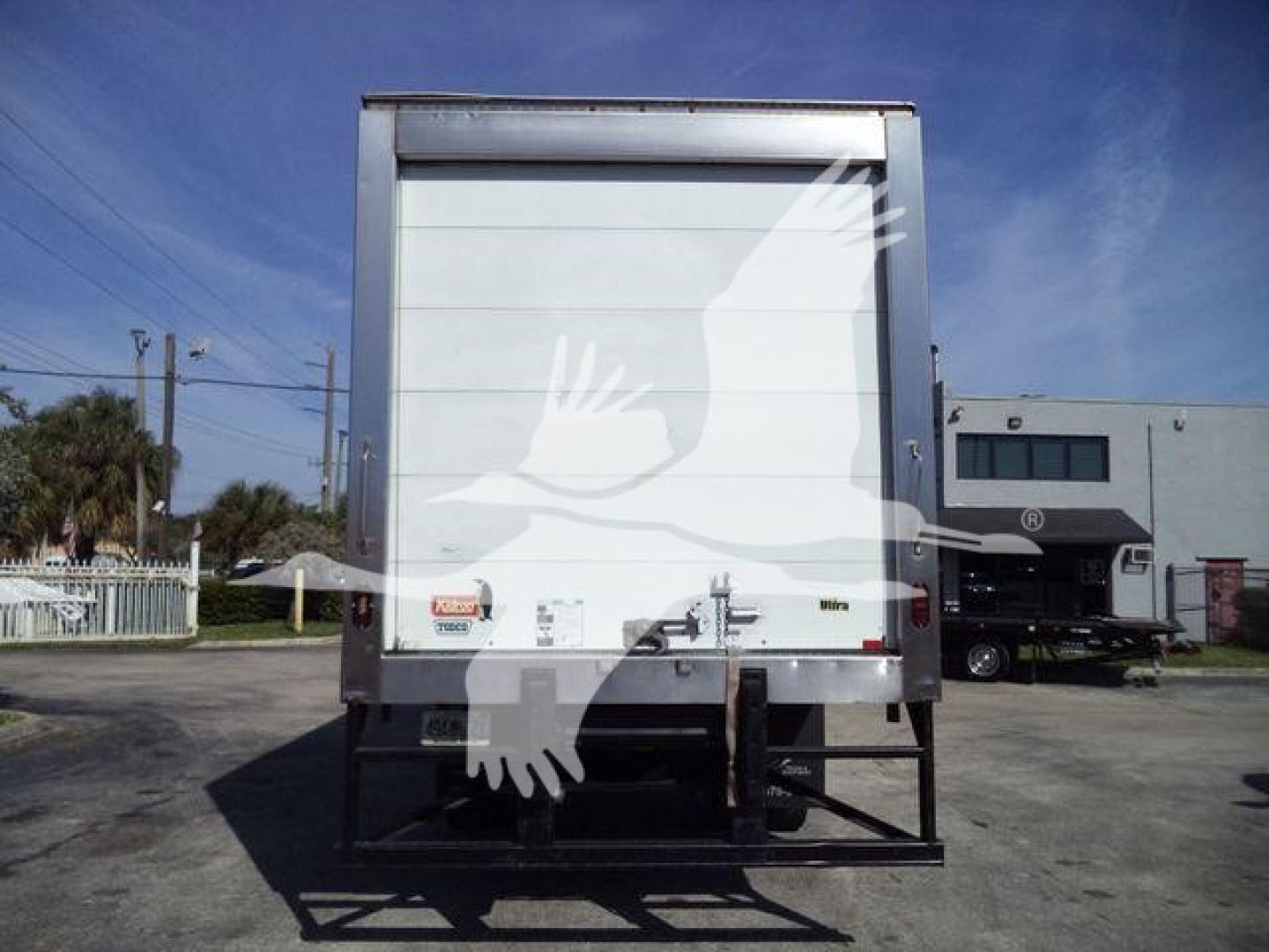 Rear view of a 2016 Freightliner M2 106 refrigerated truck with a liftgate and metal rear doors. Visible labels and reflective markings on the back doors.