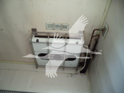 Refrigerated Freightliner M2 106 interior showing a white appliance/box mounted on wall with tubing and metal brackets.