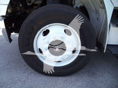 Wheel and tire on Freightliner M2 106 front, white steel rim with hub and lug nut pattern visible.