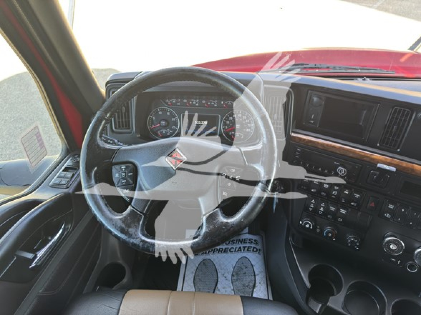 Truck interior showing steering wheel and dashboard of a 2018 International LT convention sleeper cab.