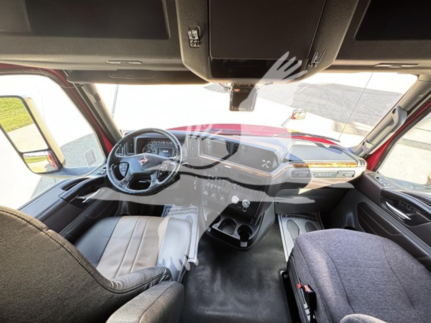 Interior view of an International LT truck cab showing steering wheel with dashboard controls and center console.