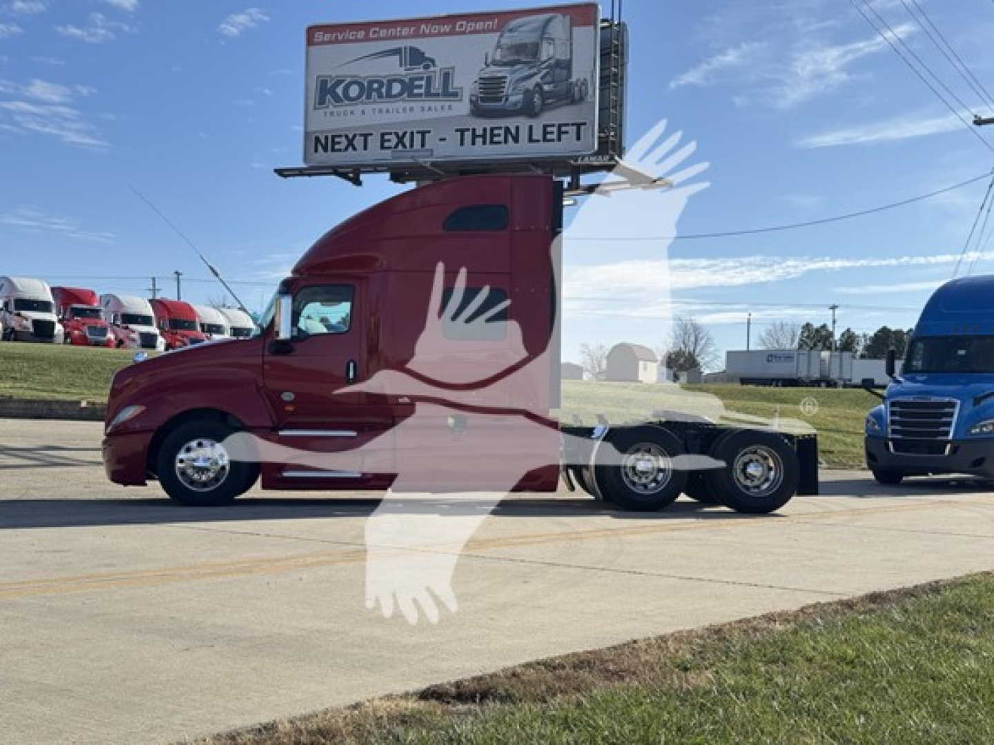 2018 International LT conventional sleeper truck in red, side view, with rear chassis and cab signboard visible, dealership lot in background.