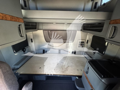 Truck cab interior cargo area of 2018 International LT sleeper showing sleeping platform and side storage cabinets.