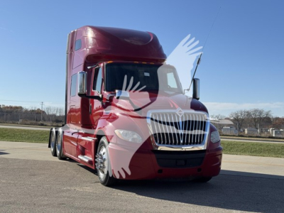 Truck front view showing large burgundy freight sleeper cab with grille, headlights, and side mirrors