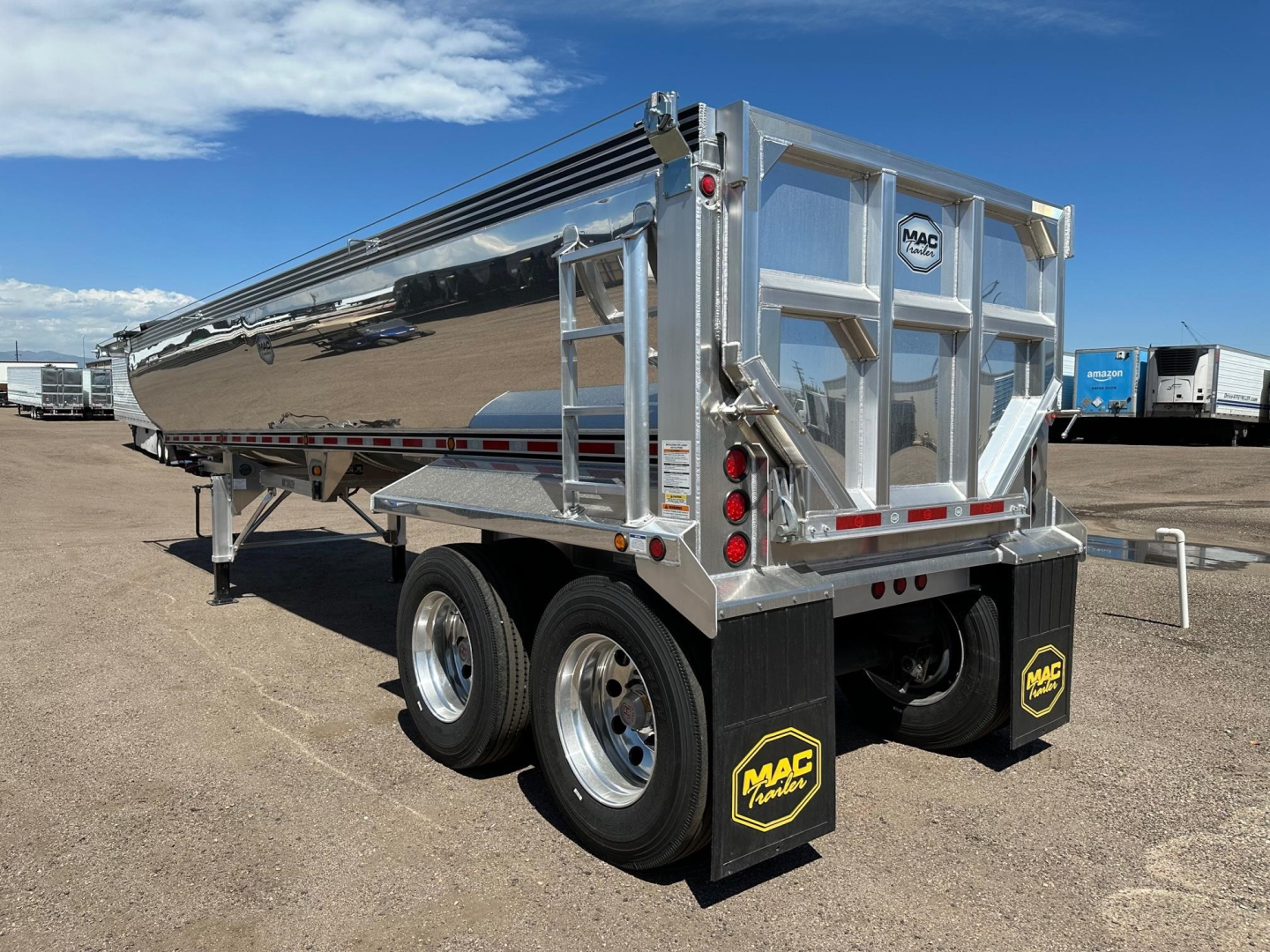 Mac Macsimiser dump trailer showing polished aluminum hopper with twin rear axles and MAC branding mud flaps.