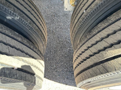 Two dual truck tires from a Mac Macsimiser half round aluminum end dump trailer showing tread patterns.